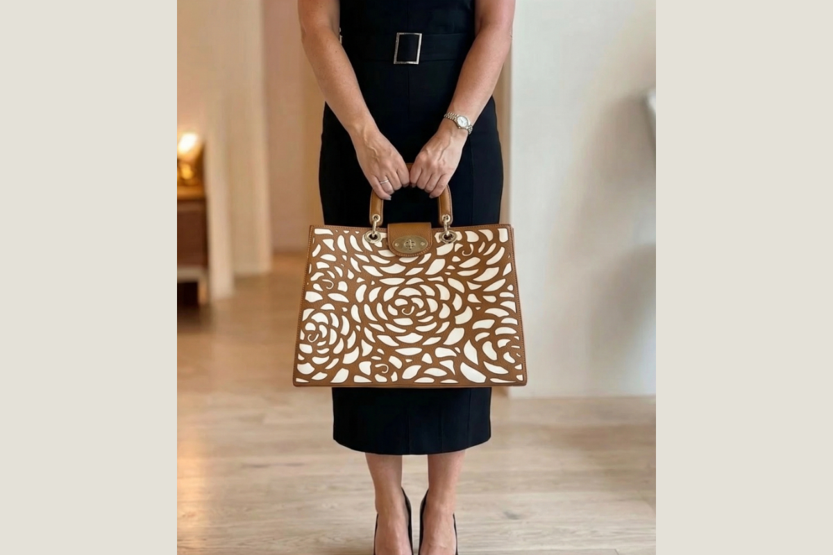 manhattan-leather-laptop-tote-bag held by a women wearing a black work dress and heels