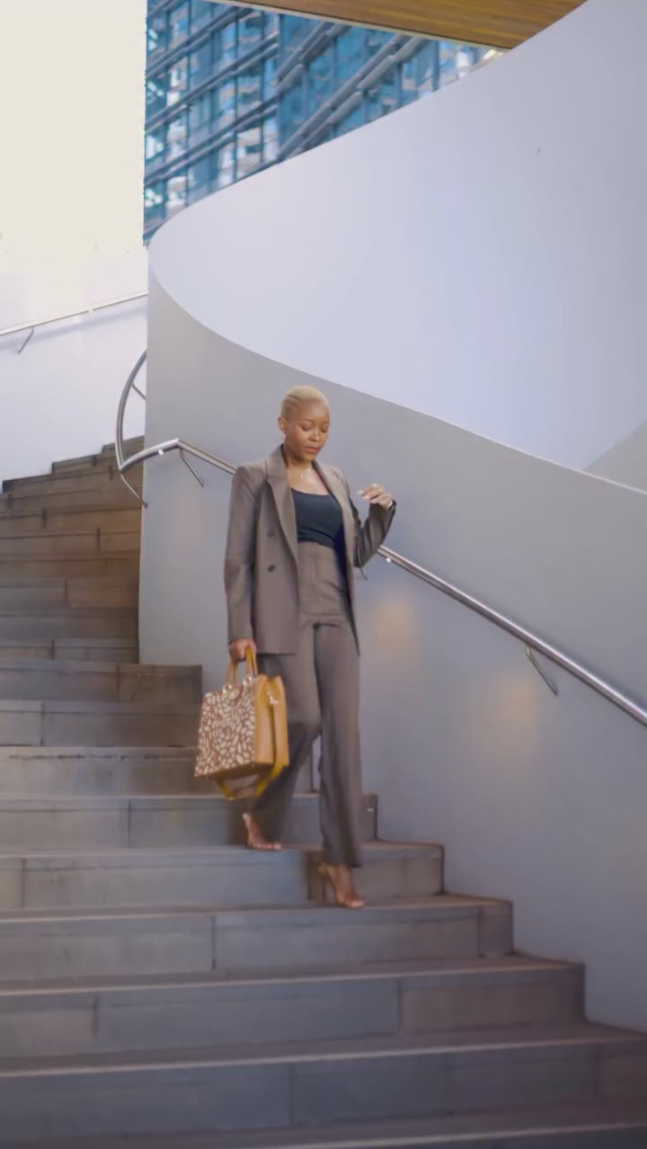 professional women carrying laptop bag down spiral staircase