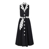 Ghost image, front view of black fit and flare polka dot midi dress.  Collar and belt is white with black polka dots and main dress is all black with white buttons on centre front. 